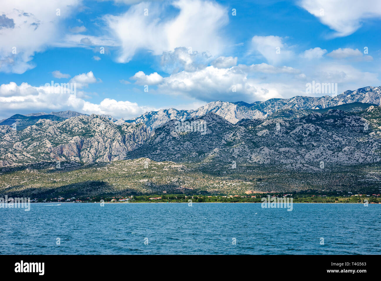 Paklenica National Park Mountains with beautiful ocean and dramatic blue sky with clouds on hot summer day. Stock Photo