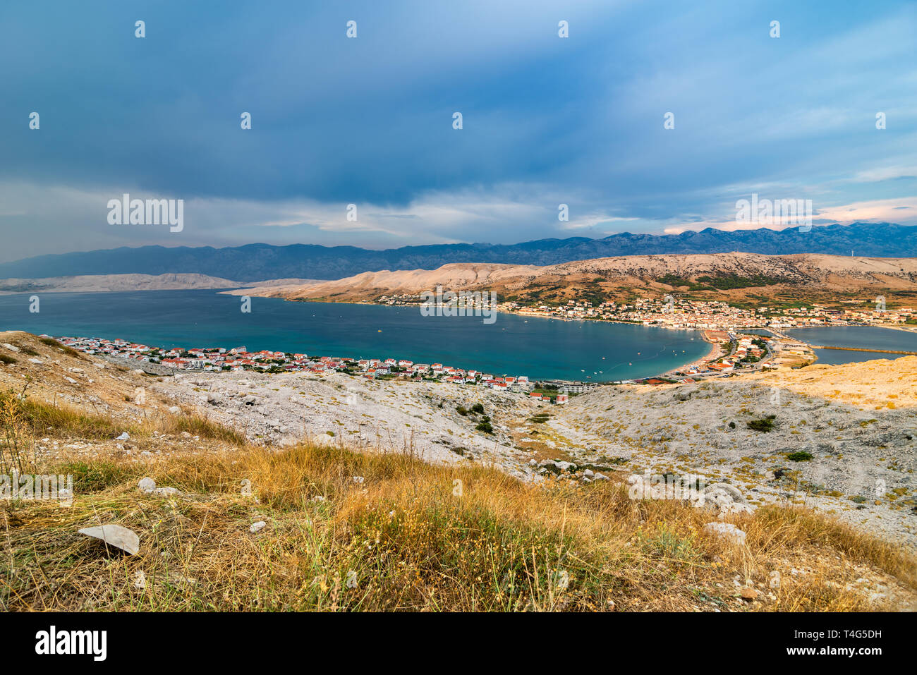 Wide angle scenic view over village on Pag island in the evening with sea and cloudy sky. Stock Photo