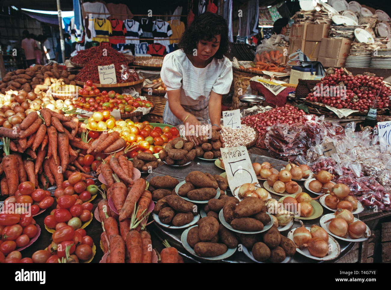 Thailand. Bangkok. Chatuchak Park weekend market. Woman working on vegetables stall. Stock Photo
