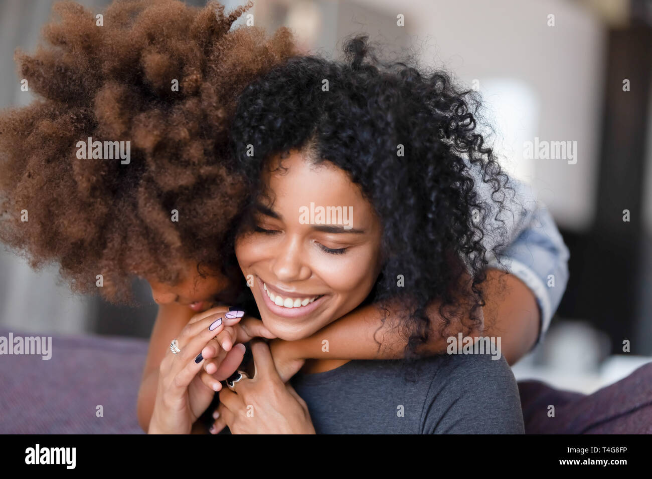Close up smiling African American mother embracing with daughter Stock Photo