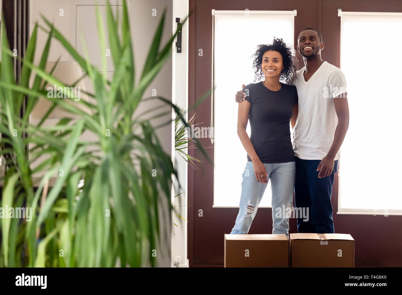 Happy African American couple standing in hall of new house Stock Photo ...