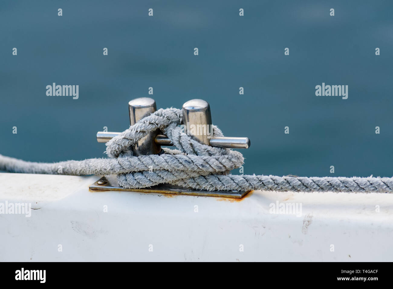 Close up of boat rope tied to nautical cleat hitch on boat Stock Photo