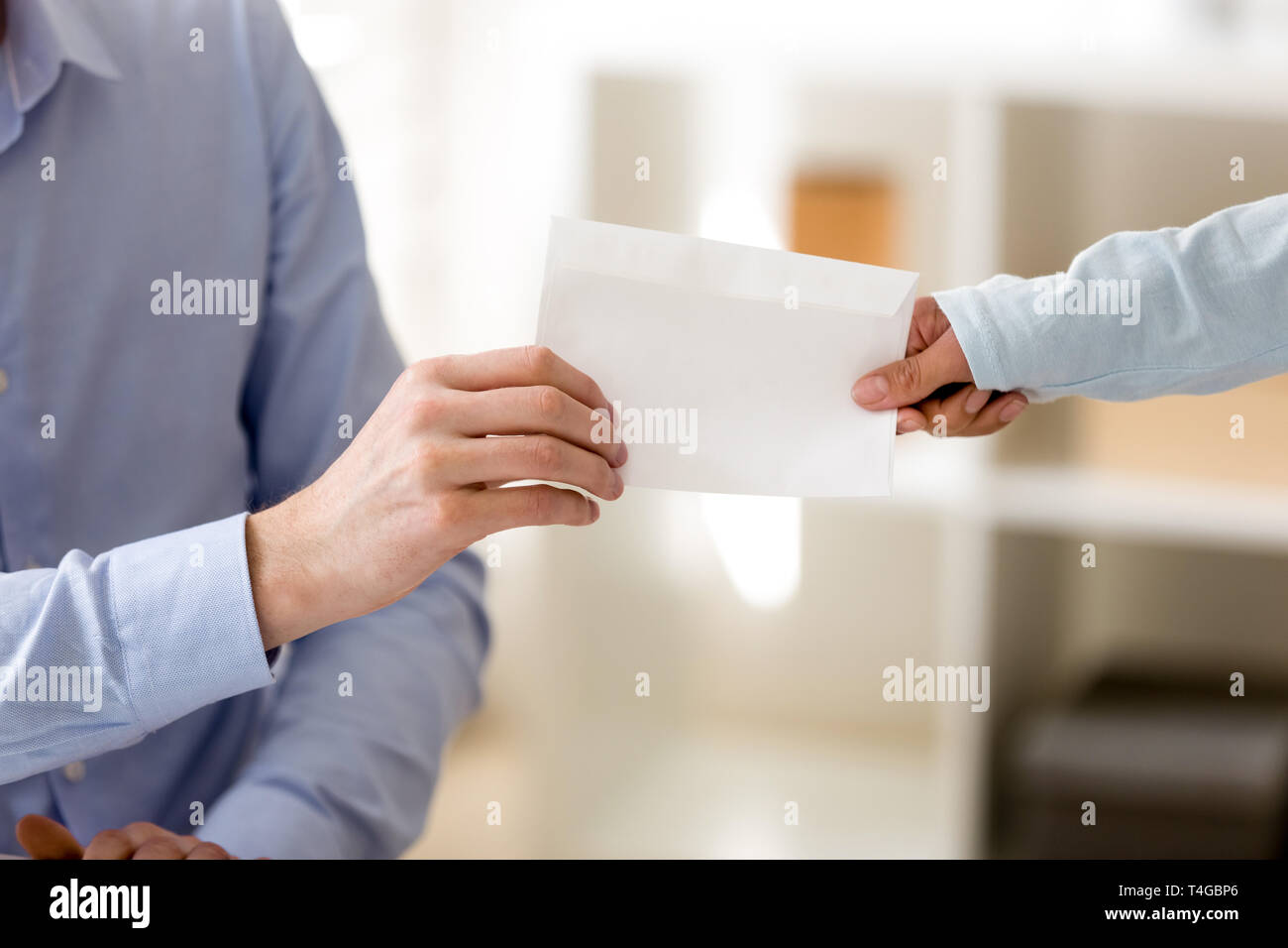 Closeup transfer of envelope from hand to hand Stock Photo