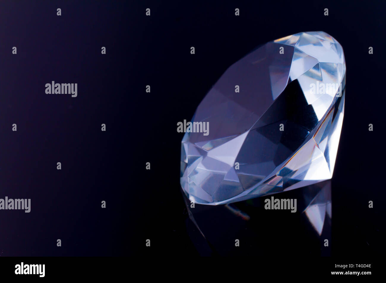 A huge diamond on a black mirror surface with a reflection of a diamond ...
