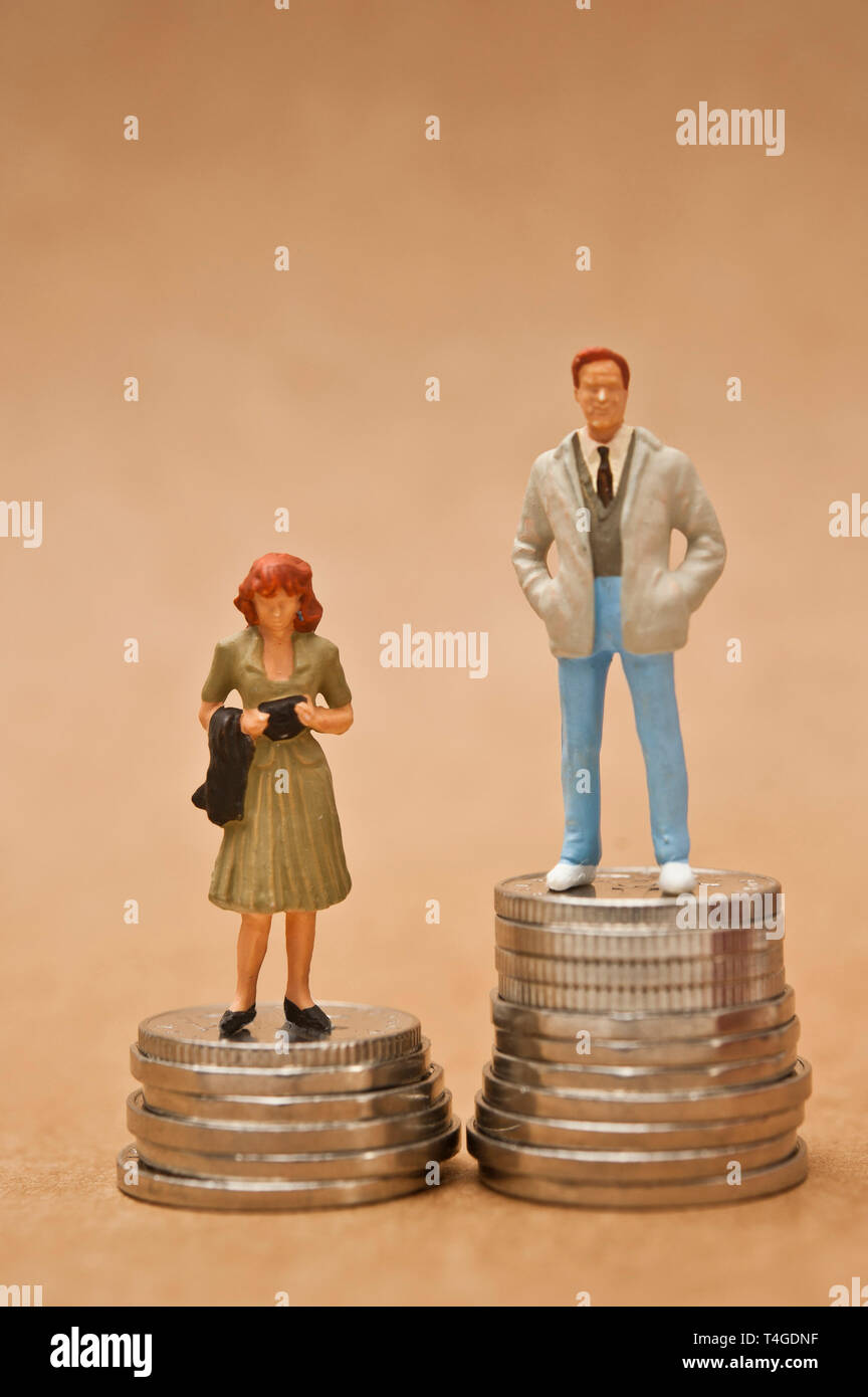 man and woman figurine standing on coins, gender pay gap concept Stock Photo