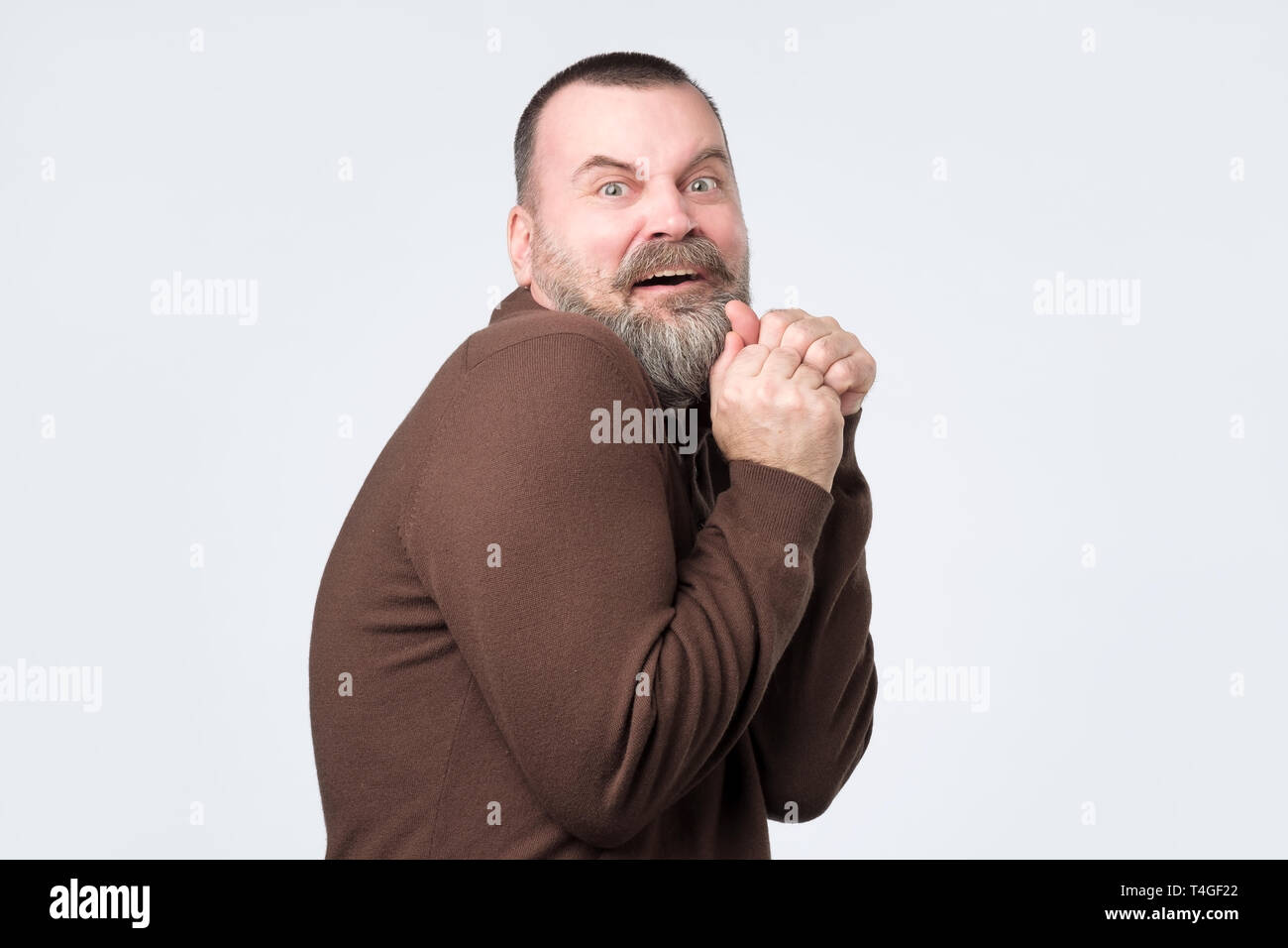 Frightened mature man in an exaggerated expression of fear. Negative facial emotion Stock Photo