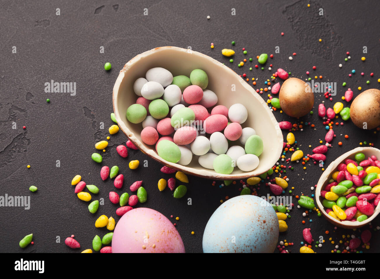 Chocolate egg filled with colorful candies Stock Photo Alamy