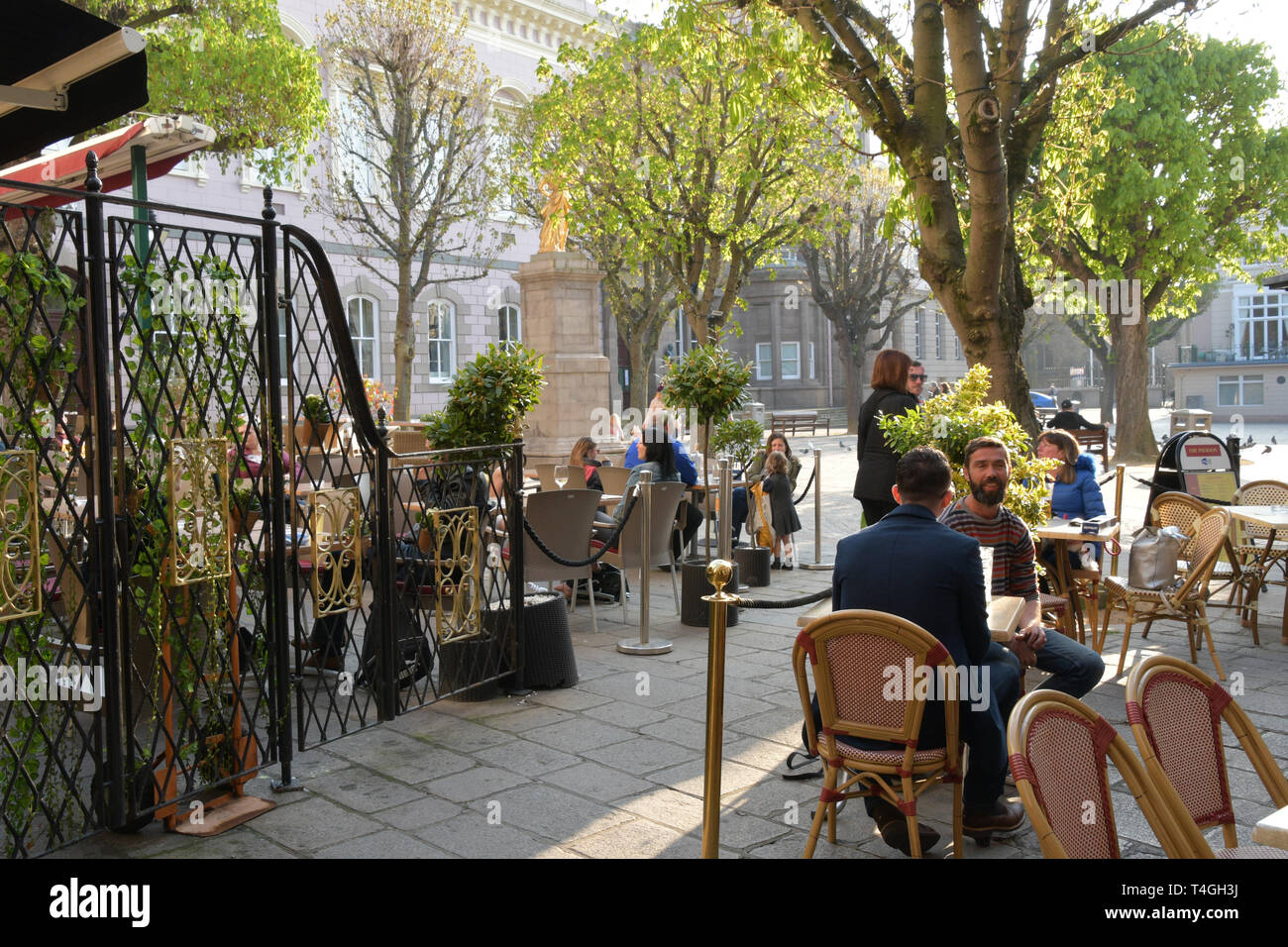 Spring sunshine enjoyed by visitors in the Royal Square, St Helier,Jersey, Channel islands Stock Photo