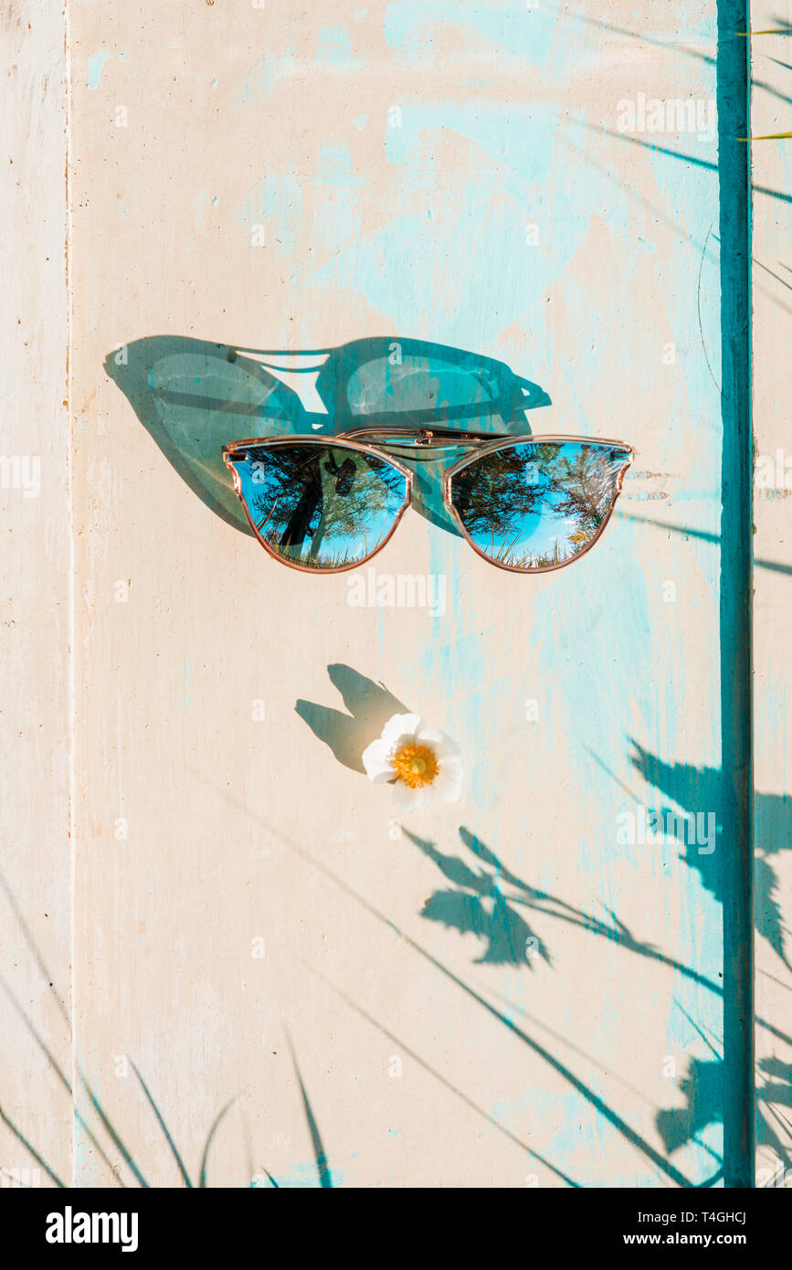 Blue mirrored solar glasses on a wooden background. Concept summer creative background, poster. Stock Photo