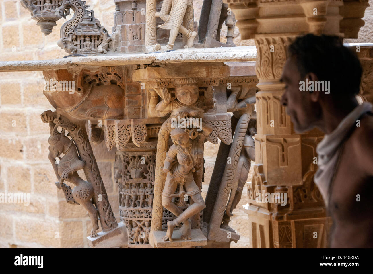 Holy man with carved stone figures in Chandraprabhu Jain Temple  jaisalmer, Rajasthan, India Stock Photo