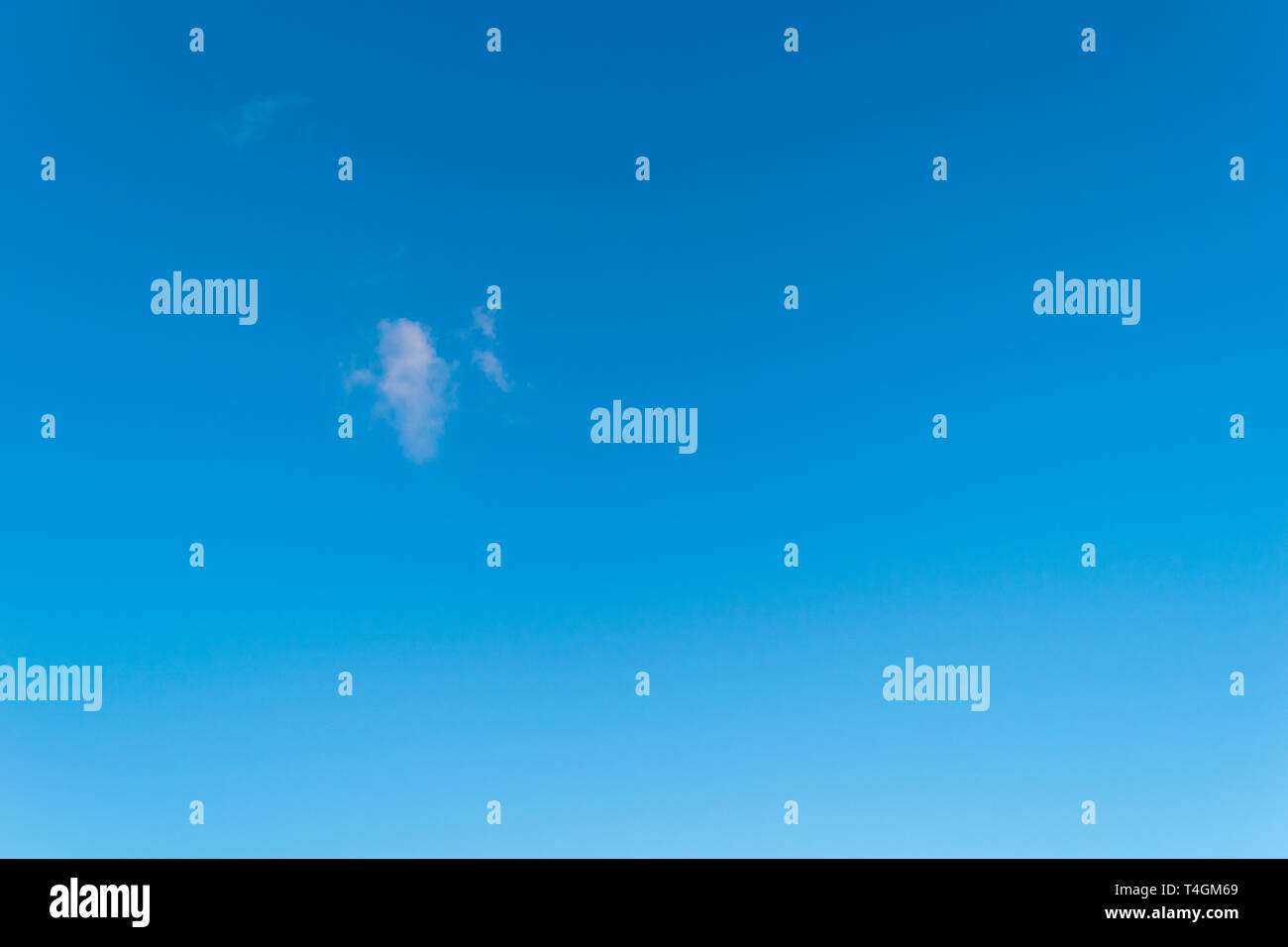 Singular fluffy cloud in a seamless gradient blue sky Stock Photo