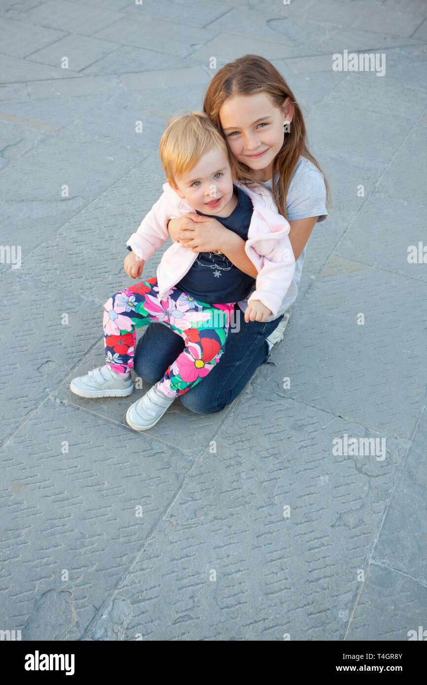 Two young girls, Piazza Unità d'Italia, Unity of Italy Square, Trieste Stock Photo