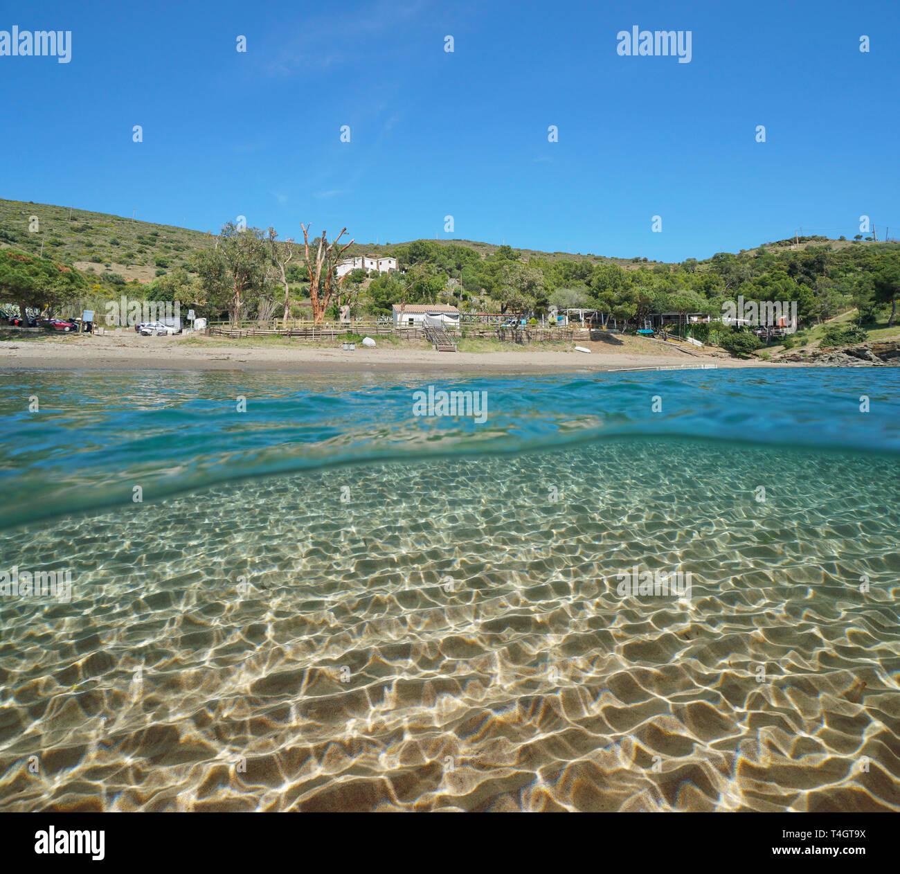Spain peaceful beach on the Mediterranean coast with sand underwater sea, Roses, Costa Brava, Catalonia, split view half over and under water Stock Photo