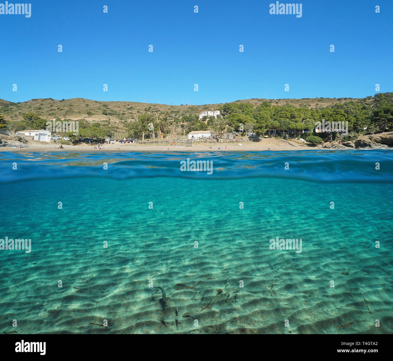 Spain peaceful beach with sandy seabed on the Mediterranean coast, split view half over and under water, Roses, Costa Brava, Catalonia Stock Photo