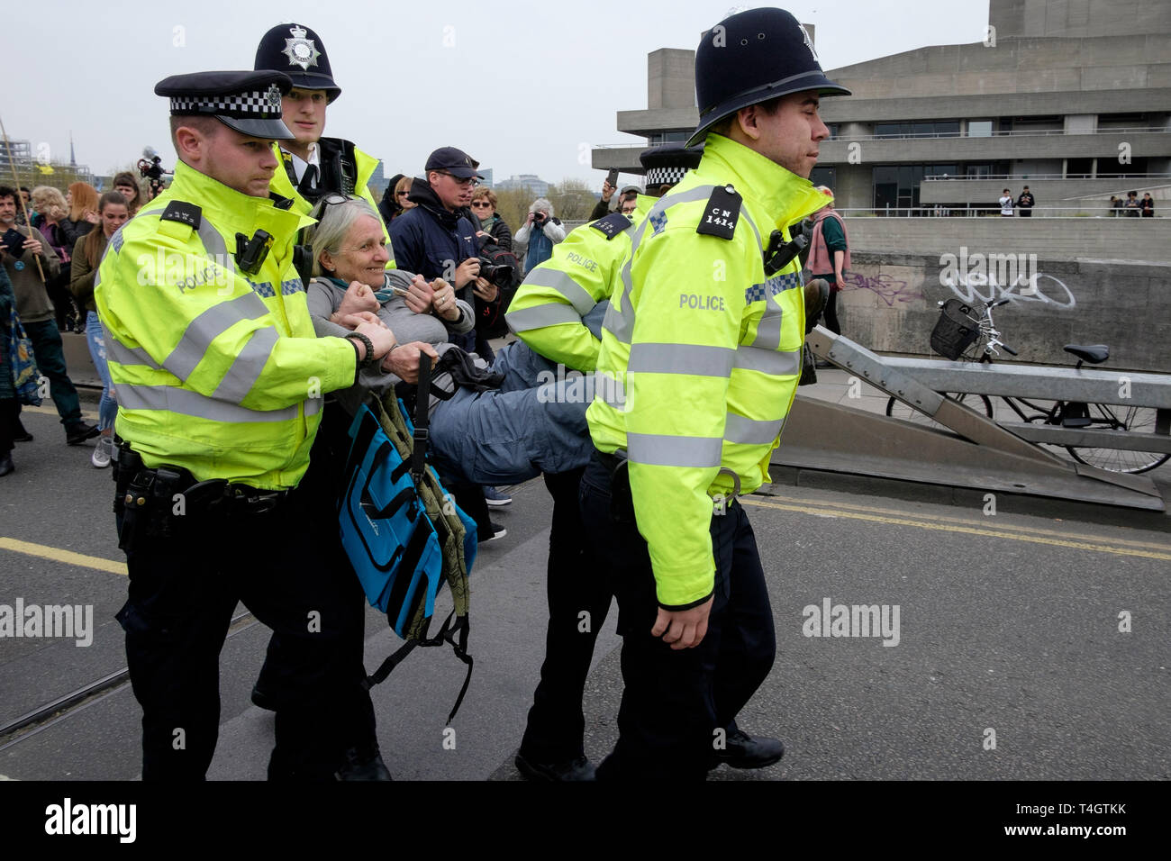 Extinction Rebellion environmental activists occupy Waterloo Bridge, London. Metropolitan Police officers arrest an elderly female demonstrator. Stock Photo