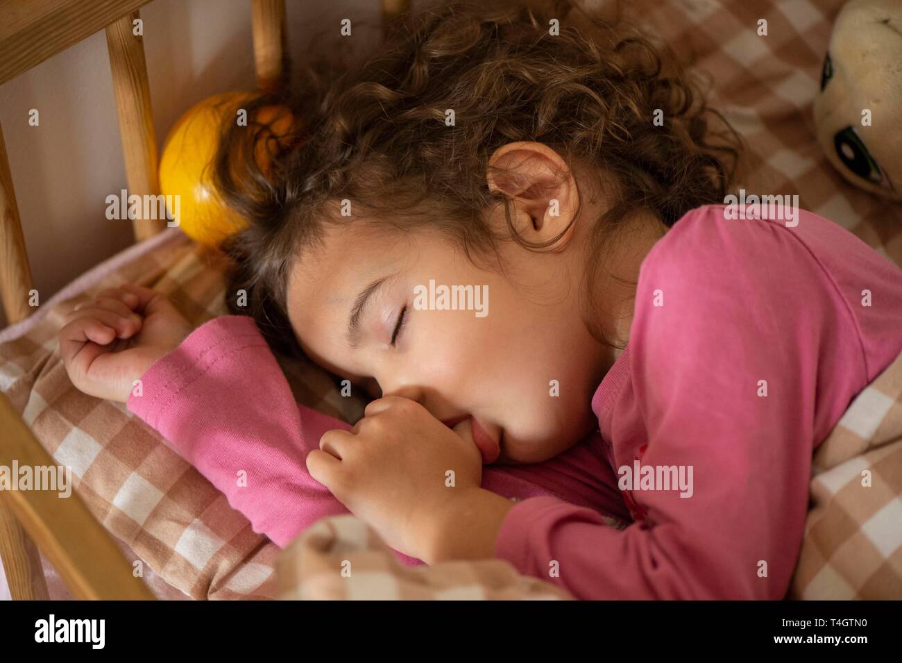 Girl, 3 years, portrait, sleeps in bed, with thumb in mouth, Germany Stock Photo