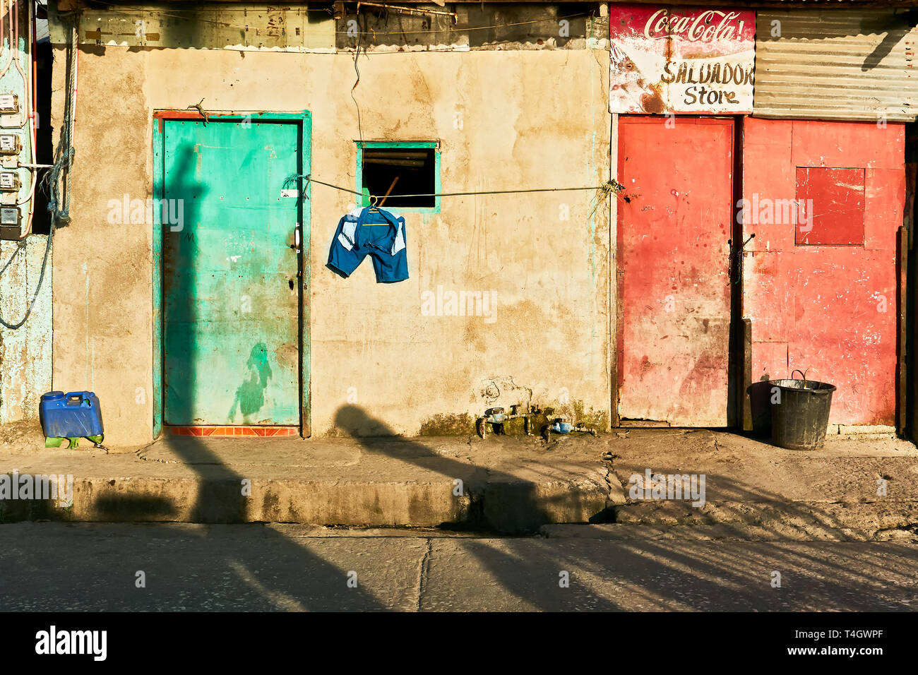 Romblon Town, Philippines - March 14, 2018: Poor building with colorful closed doors and laundry hanging on the line for drying at late afternoon Stock Photo