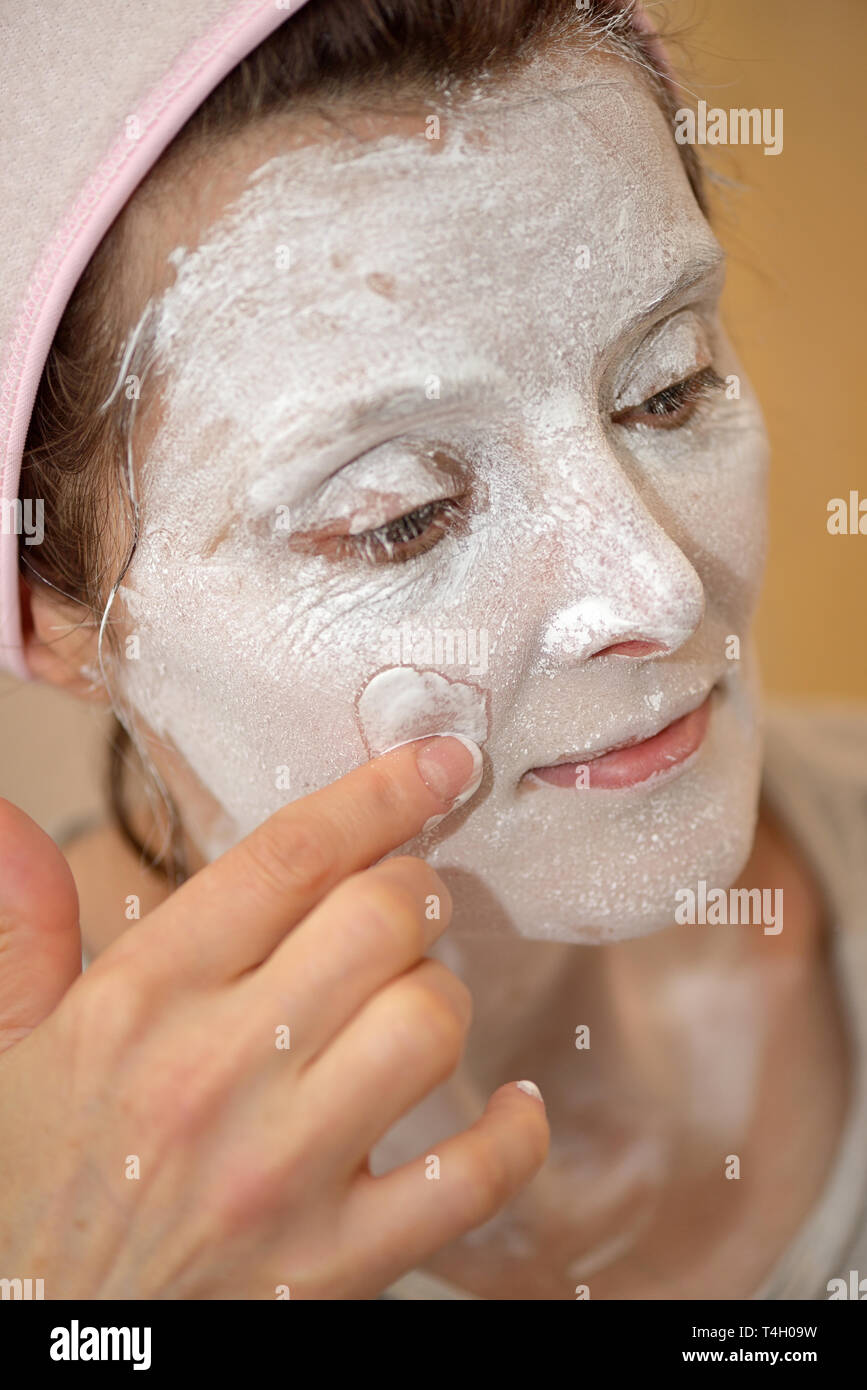 Woman applying pearl powder facial mask Stock Photo