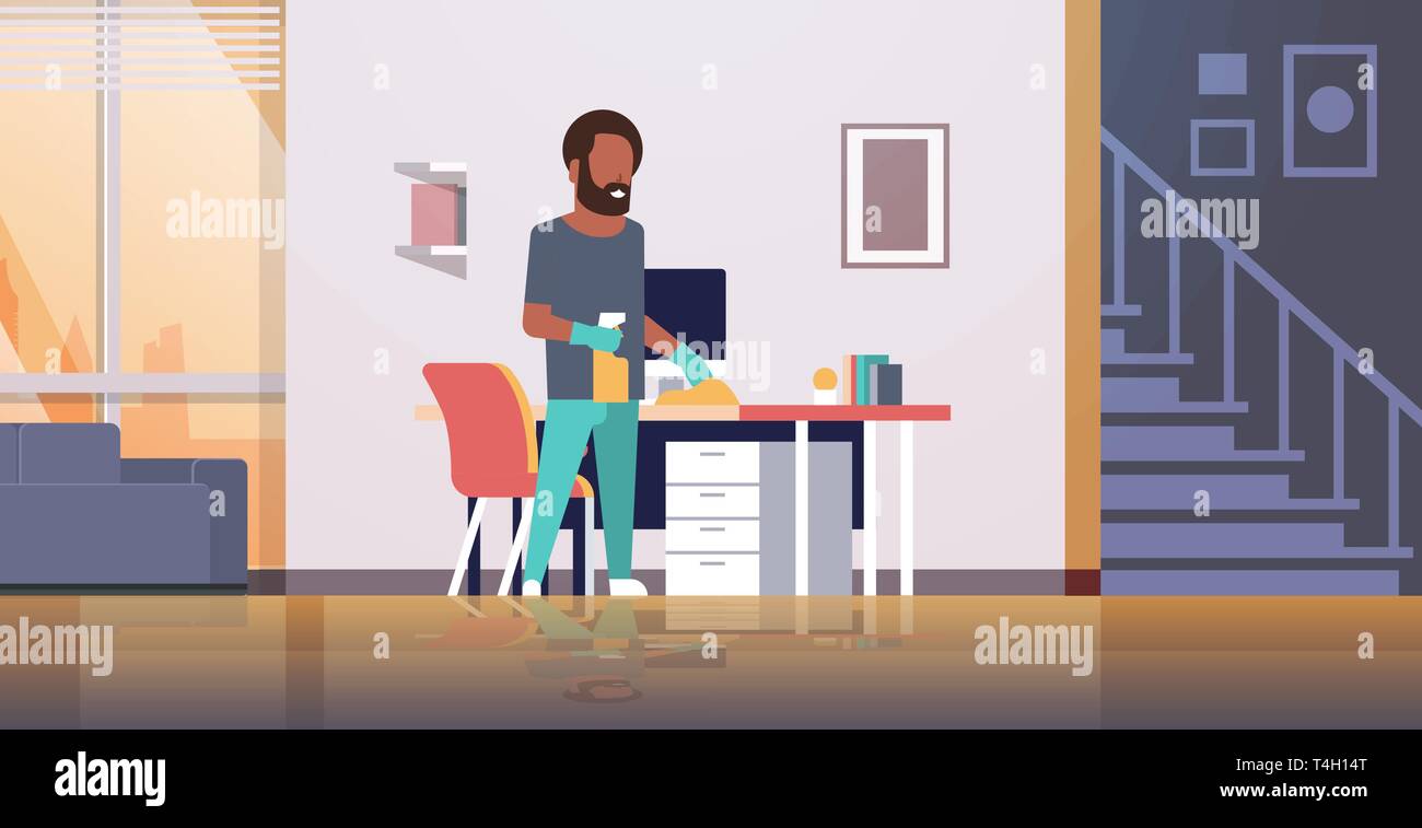 man cleaning computer table with duster african american guy wiping ...