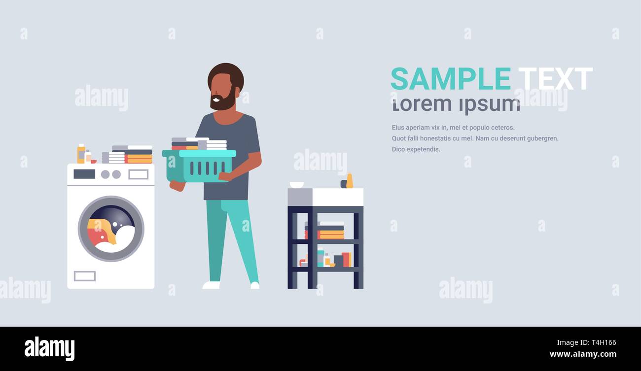 man with clothes basket standing near washing machine african american