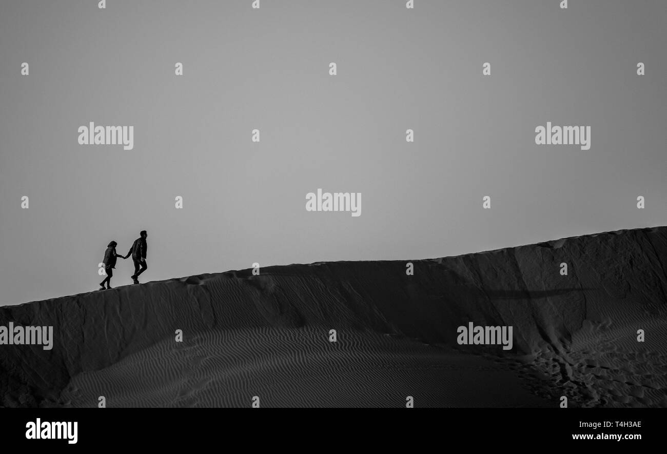 Couple walking on sand dunes Stock Photo Alamy