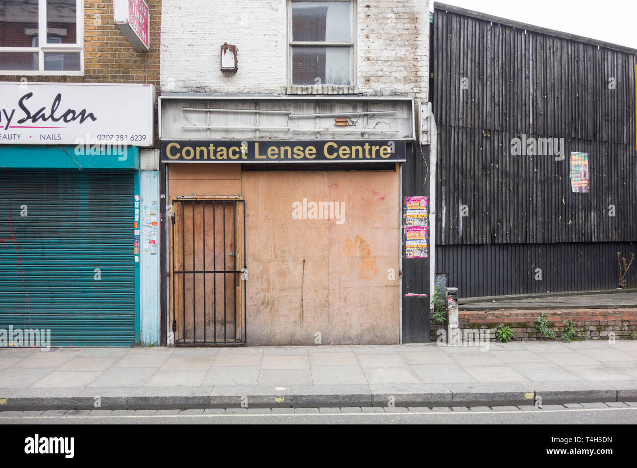 A boarded-up contact lens shop front in Fulham, London, UK Stock Photo