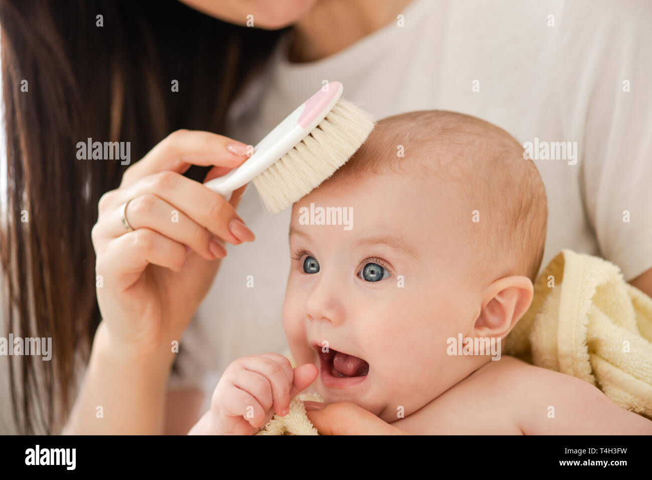 Young mother combing hair her baby girl Stock Photo - Alamy