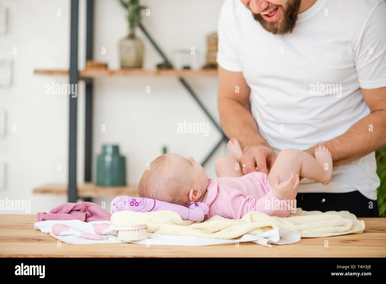 Child is lying on table, dad smiles. Stock Photo