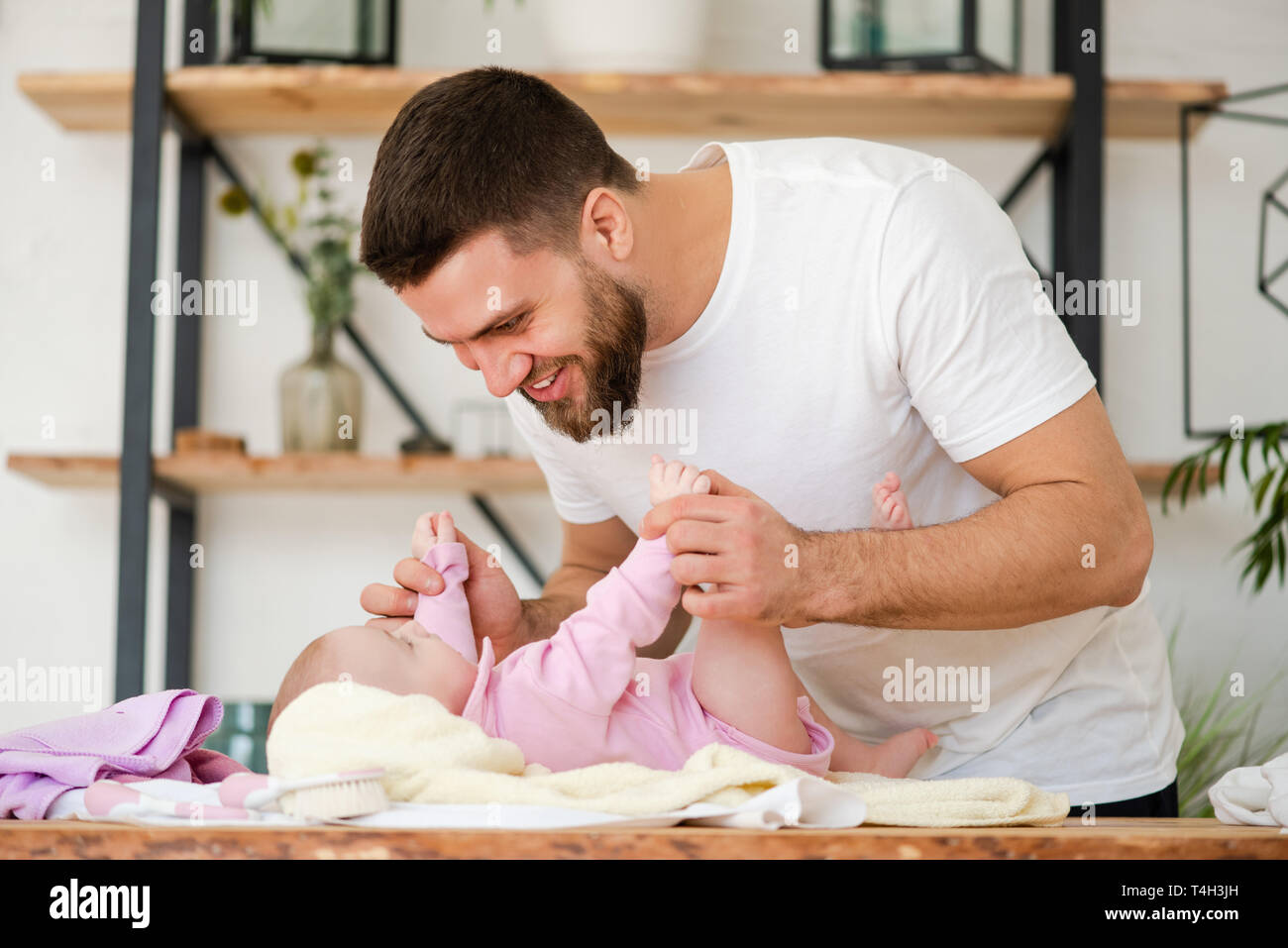 Young man play with laying baby girl Stock Photo