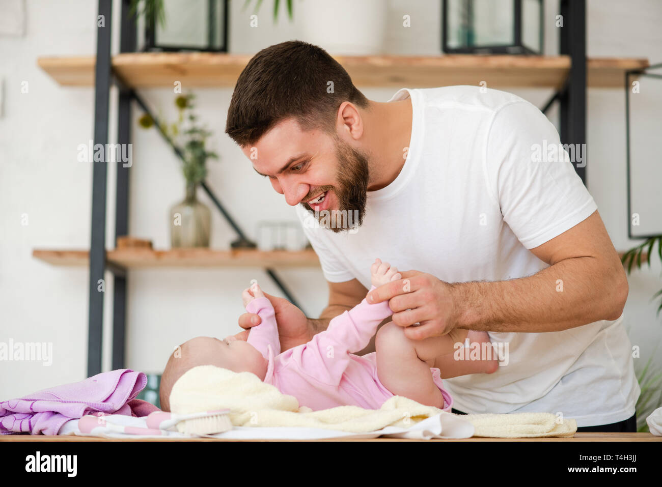 Young man play with his laying baby girl. Stock Photo