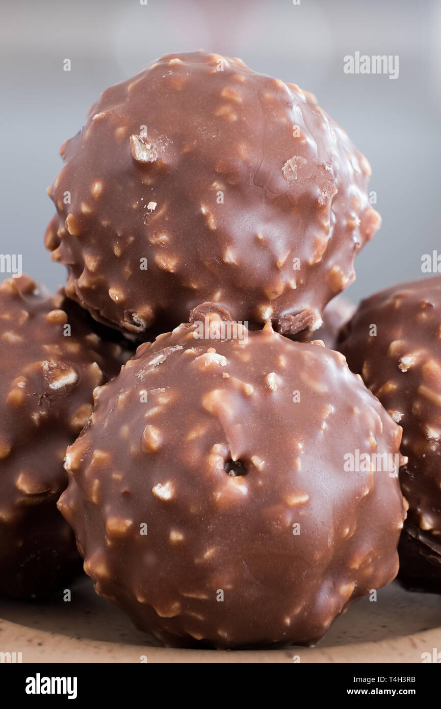 Four Round Chocolate and Crushed Almond Crispy Balls on a small serving  plate with a soft blurred background. A good image for a delicatessen,  Sweet R Stock Photo - Alamy