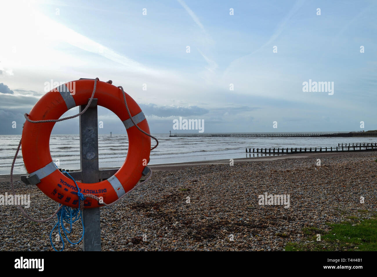 Orange life saving ring attached to a post on Littlehampton seafront Stock Photo
