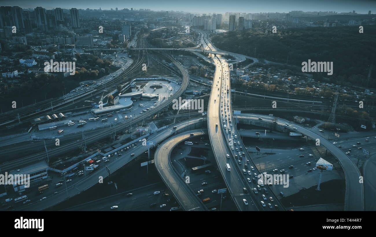Night Aerial Urban Traffic Road System. Busy Downtown Route Development City Highway Junction Overview. Cityscape Car Motion Transport. Dark Blue Cine Stock Photo