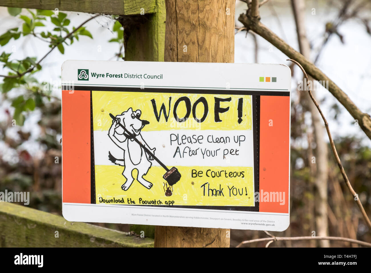 Council notice outdoors on post reminding UK dog owners to 'Be courteous & clean up after your pet'.  Pick up dog poo sign. Stock Photo