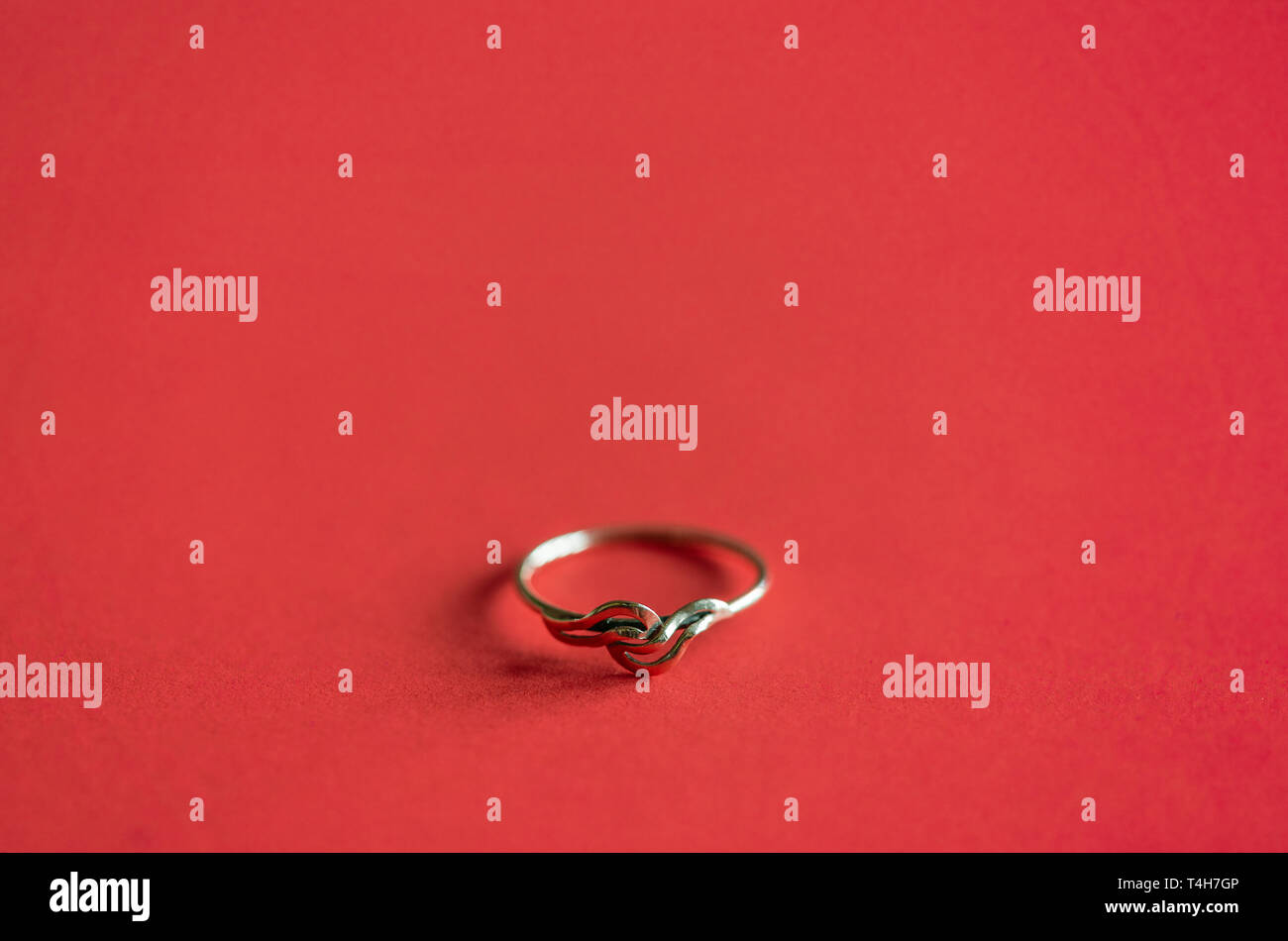 Close up / macro of a gold ring on coral red coloured background Stock Photo