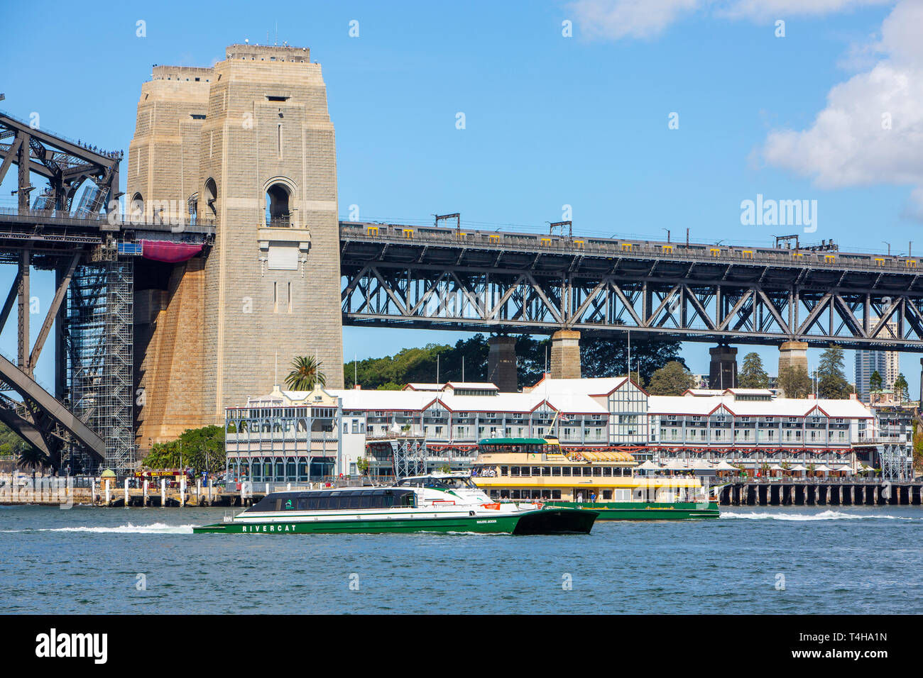 Sydney train on the harbour bridge with sydney ferry and sydney rivercat boat passing below,Sydney,Australia Stock Photo