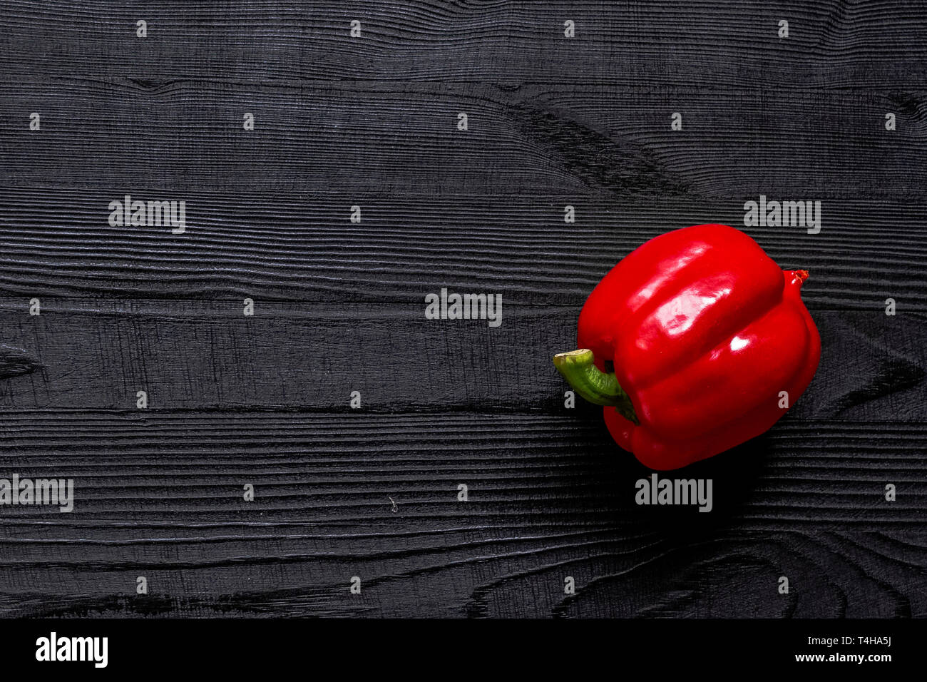 Red sweet bell pepper on black rustic wooden table background. Top view ...