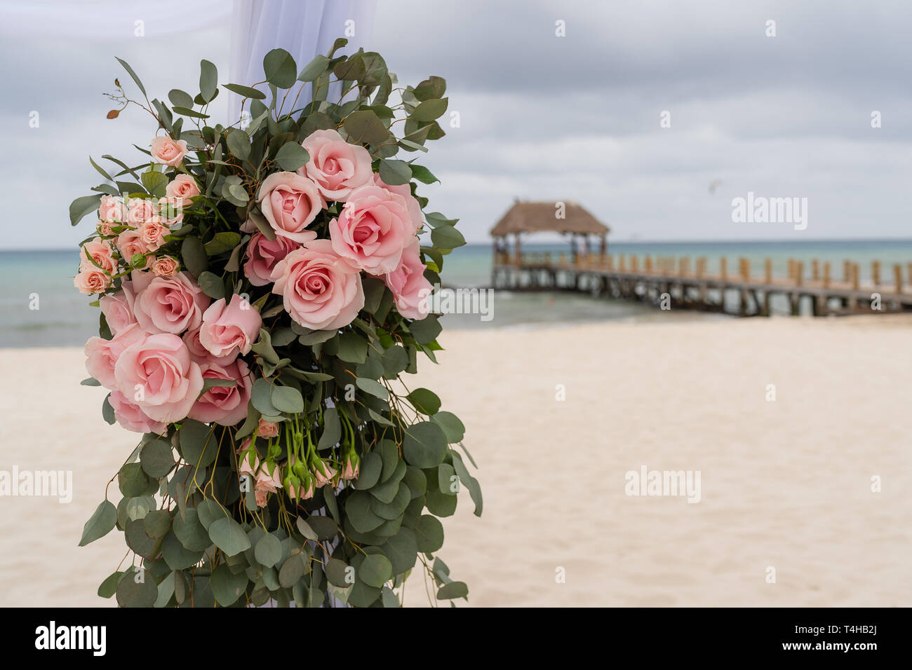 Romantic decoration with roses of a beach wedding on the beach with sea in the background Stock Photo