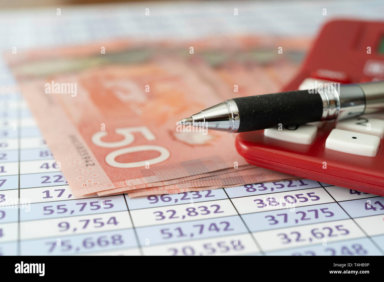 Canadian Dollar Notes on spreadsheet with Calculator with pen Stock