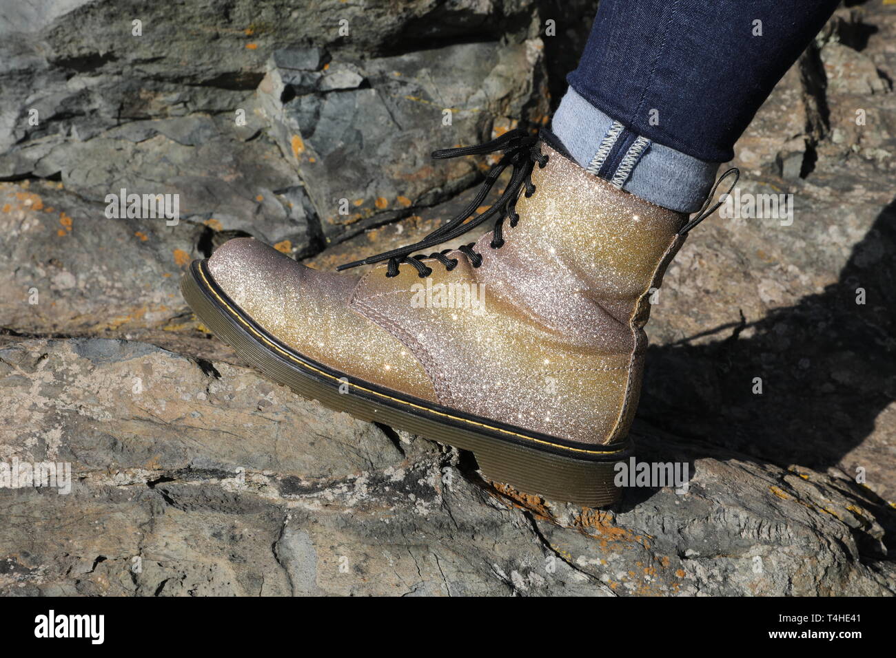 Sparkly Gold Dr. Martens with Denim Jeans Section Stock Photo