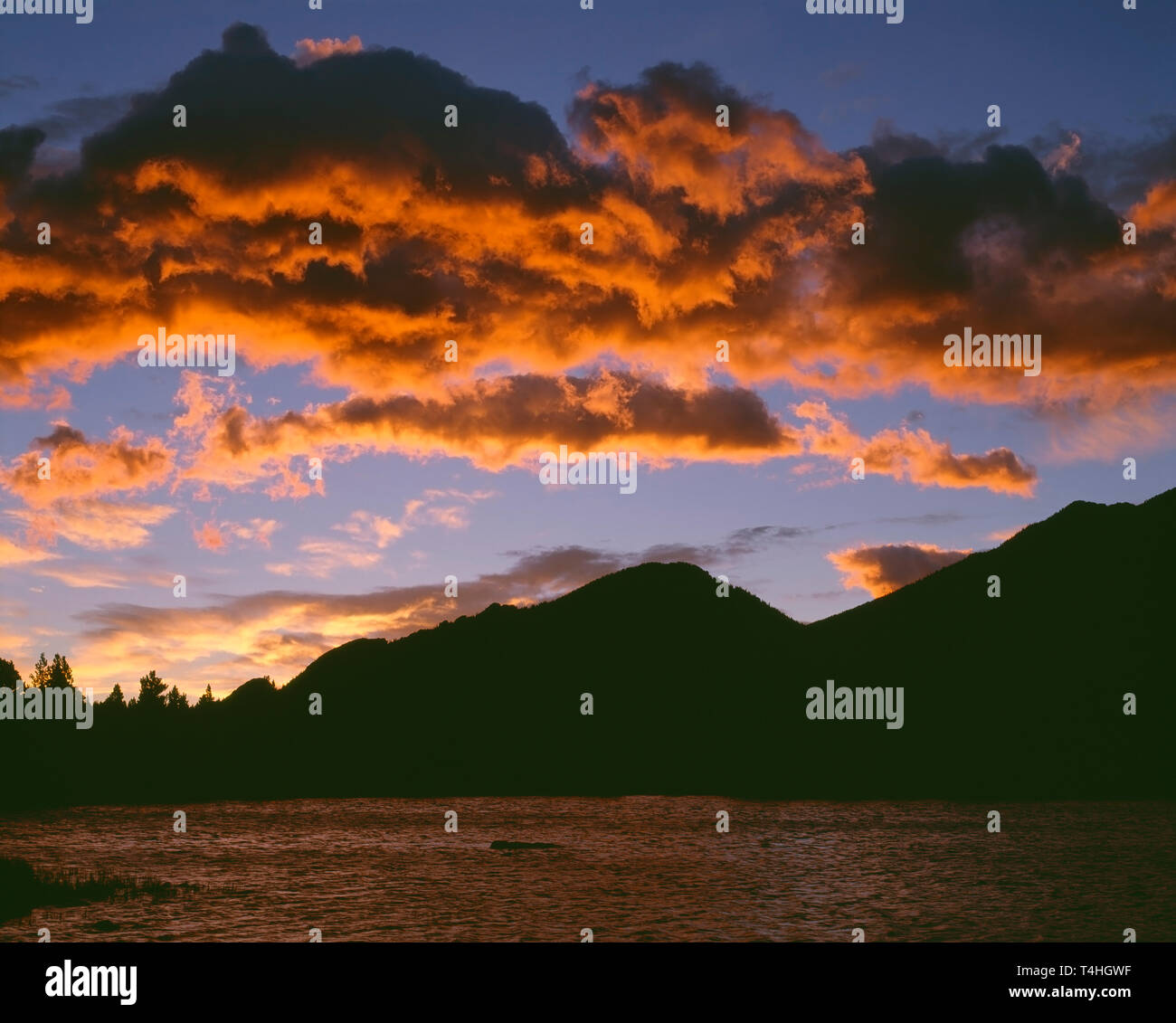 USA; Colorado; Rocky Mountain National Park; Sunrise reddens  clouds above Bear Lake. Stock Photo