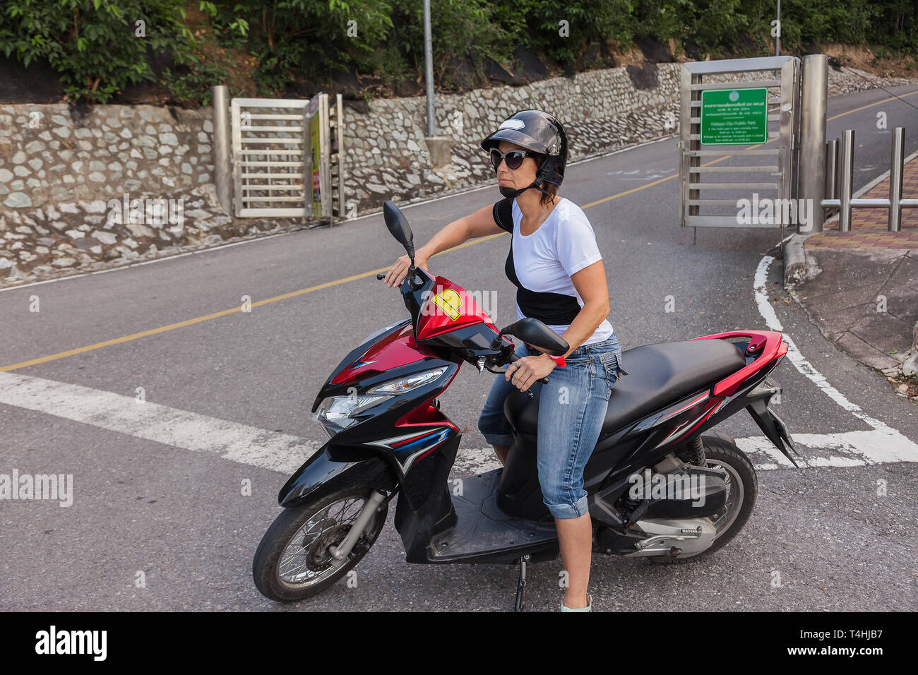 Woman on a scooter with helmet and sunglasses Stock Photo Alamy
