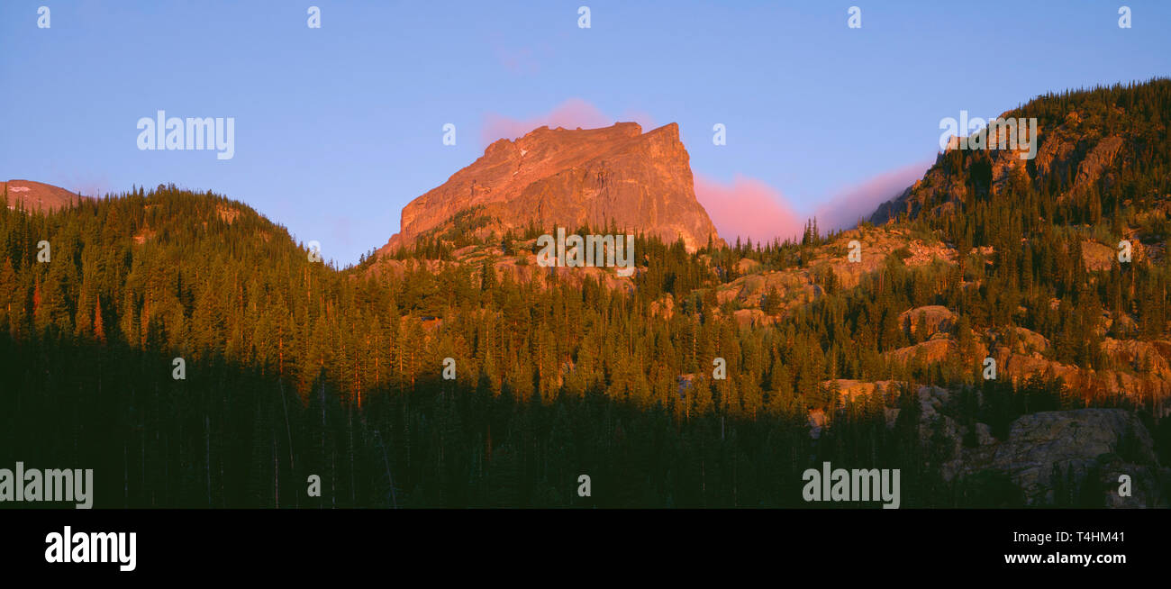USA; Colorado, Rocky Mountain National Park, Sunrise reddens Hallett Peak and clouds above Bear Lake. Stock Photo