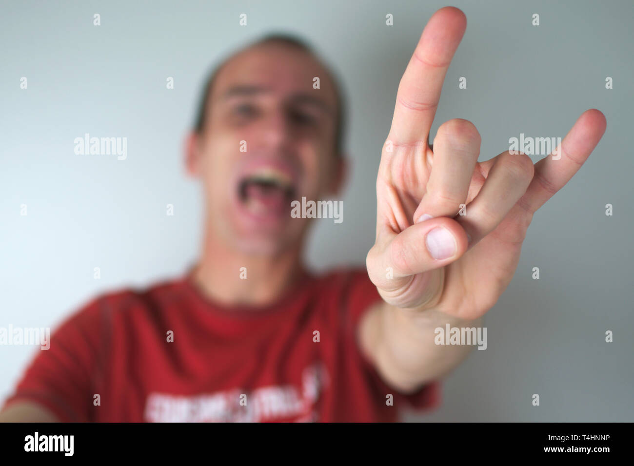 Sudio shot of a man making the sign of the horns, an unmistakable gesture of heavy metal culture. Stock Photo