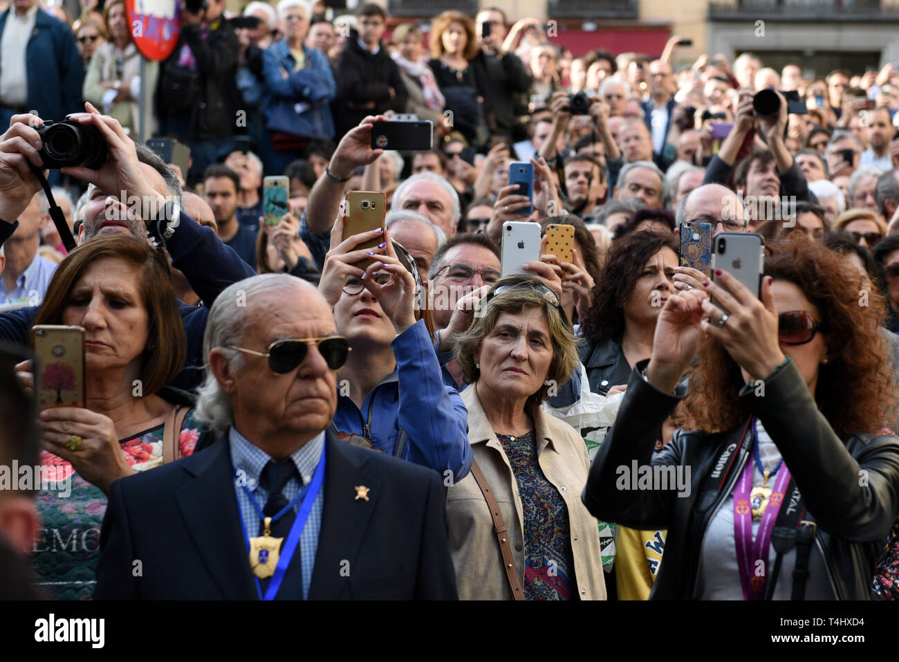 Faithful are seen taking pictures during the 'Cristo de Los Alabarderos' procession in Madrid. Cristo de Los Alabarderos procession, also known as the procession of Spanish Royal Guard, took place on the Holy Tuesday and in Good Friday in Madrid. Penitents carried a statue of Jesus Christ from 'De las Fuerzas Armadas' church to 'Real' palace in central Madrid and on Good Friday penitents will march in reverse, this has been celebrated since 1753 and it is one of the most important processions of the Holy Week in Madrid. Stock Photo