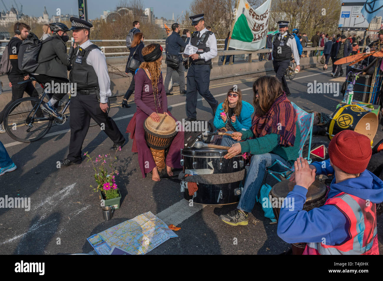 London, UK. 17th Apr 2019. Playing music to commuters and the police - Morning on Waterloo Bridge sees the camp awake and commuters make their progress on foot and bike across the river - Day 3 - Protestors from Extinction Rebellion block several junctions in London as part of their ongoing protest to demand action by the UK Government on the 'climate chrisis'. The action is part of an international co-ordinated protest. Credit: Guy Bell/Alamy Live News Stock Photo