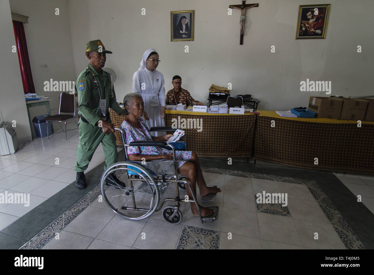 Yogyakarta, INDONESIA. 17th Apr, 2019. Voting officers assisted an elderly person to vote at a polling station in a monastery in Yogyakarta, Indonesia, Wednesday, April 17 2019. Millions of Indonesians voted in presidential and legislative elections with candidates for President Joko Widodo and Prabowo Subianto a former son-in-law general Suharto led Indonesia for 32 years. Credit: Slamet Riyadi/ZUMA Wire/Alamy Live News Stock Photo