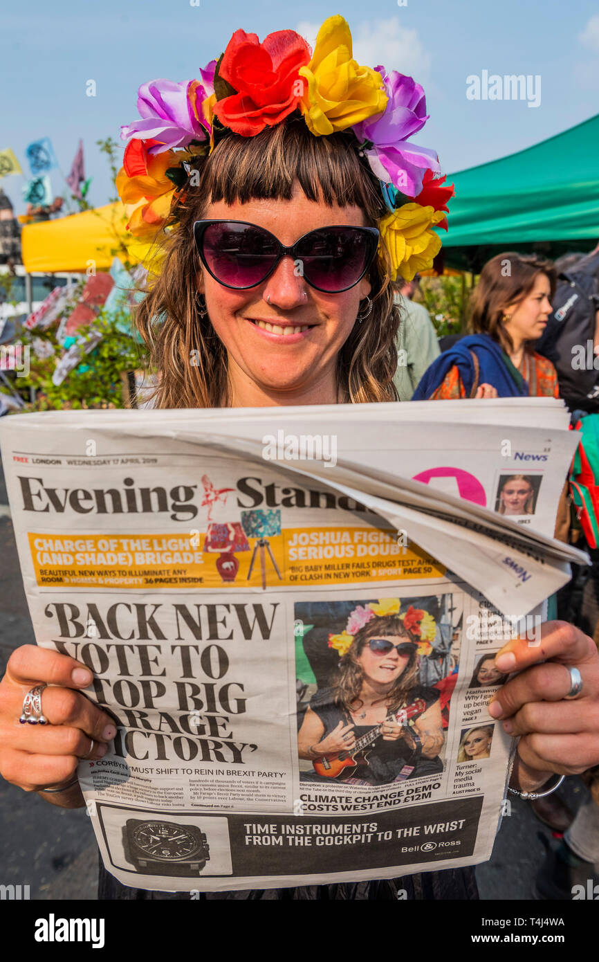 London, UK. 17th Apr, 2019. A musician is amused to see her picture on the front of the Evening Standard, but turns serious on reading the article inside -  The festival continues on Waterloo Bridge as the police back off for a while - Day 3 - Protestors from Extinction Rebellion block several junctions in London as part of their ongoing protest to demand action by the UK Government on the 'climate chrisis'. The action is part of an international co-ordinated protest. Credit: Guy Bell/Alamy Live News Stock Photo