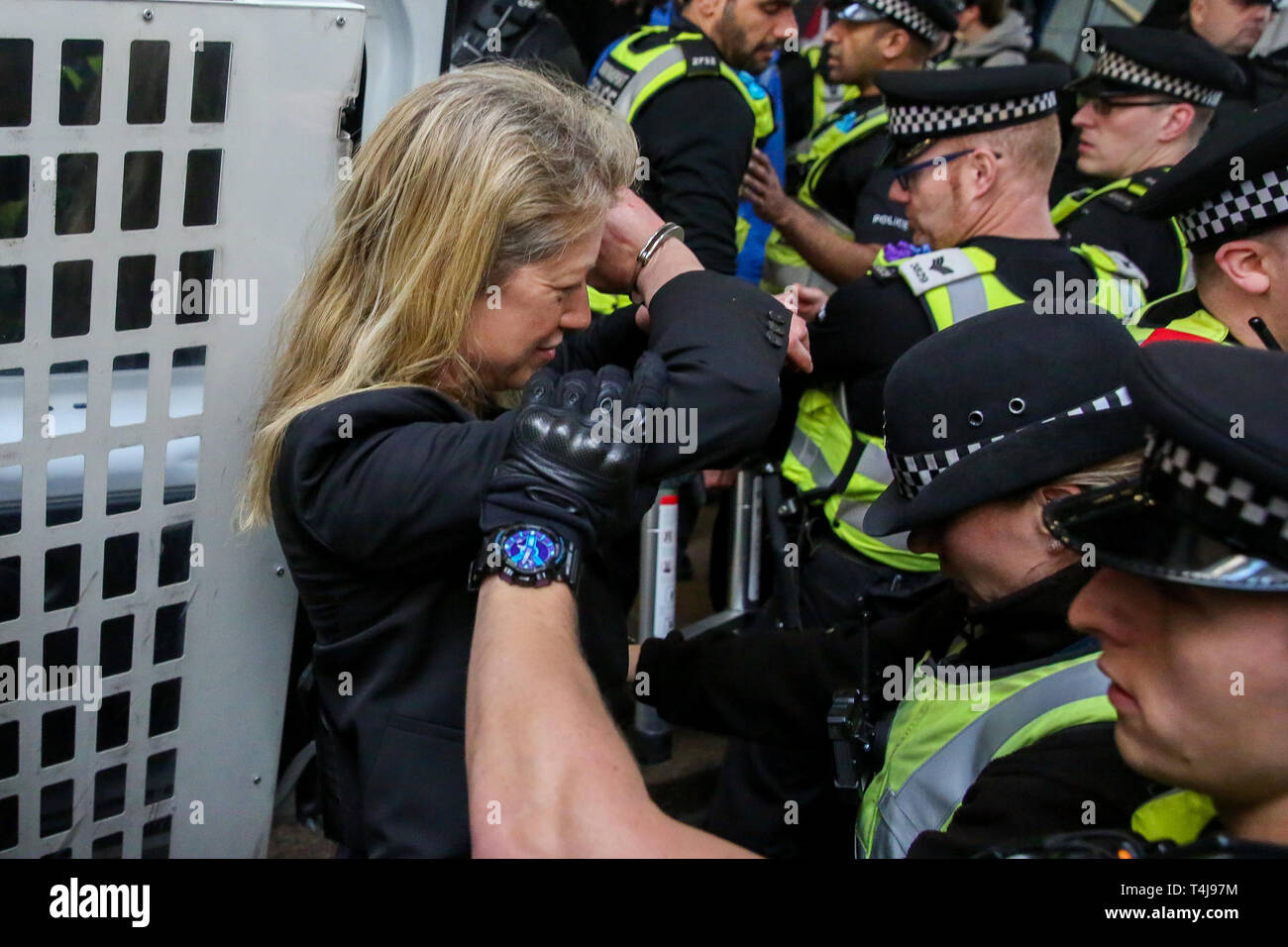 British Transport Police officers are seen arresting an environmental activist from the Extinction Rebellion campaign group at Canary Wharf station during the third day of the Extinction Rebellion Climate Change protest.  The group is demanding decisive action from the UK Government on the environmental crisis. Stock Photo