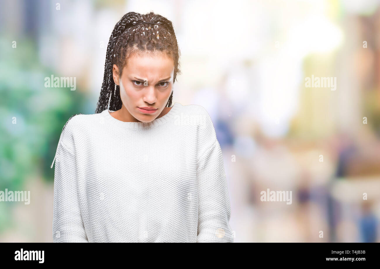 Young braided hair african american girl wearing winter sweater over isolated background skeptic and nervous, frowning upset because of problem. Negat Stock Photo